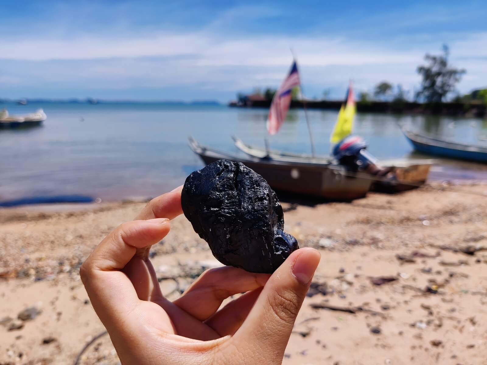 Many pieces of coal wash up on the beach next to a jetty that used to transport coal in Negeri Sembilan (Nicole Fong)